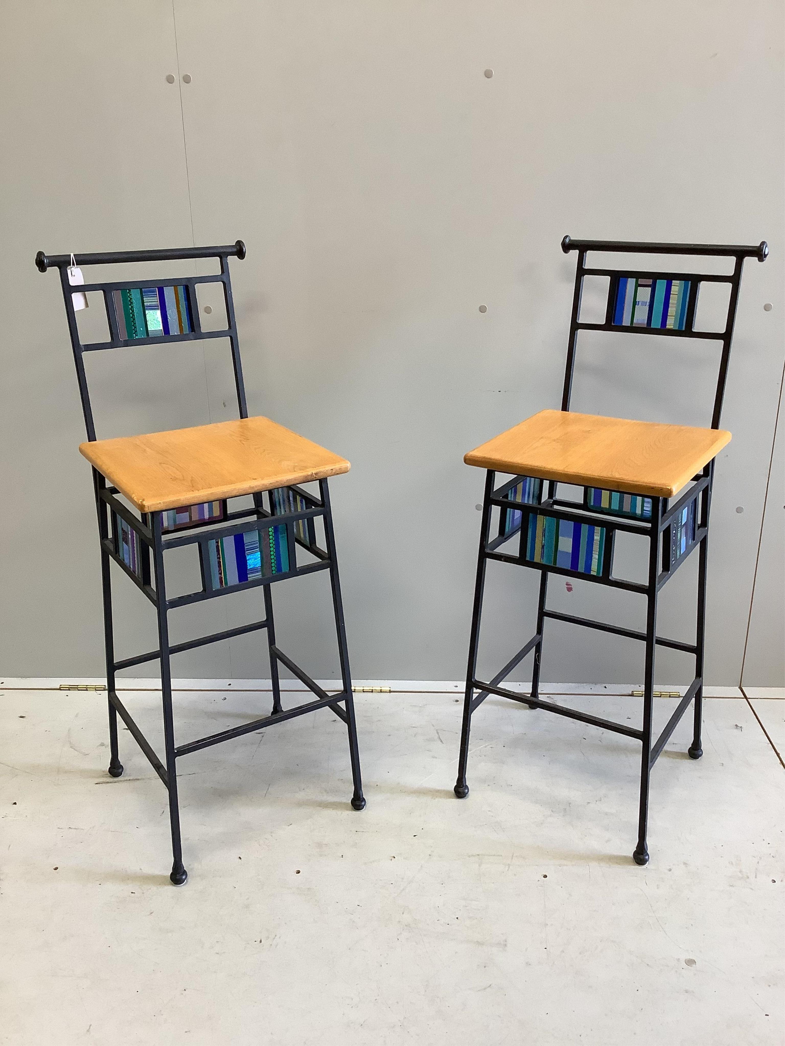 A pair of wrought iron and gold oak bar stools with coloured glass panelling, width 37cm, height 104cm. Condition - fair